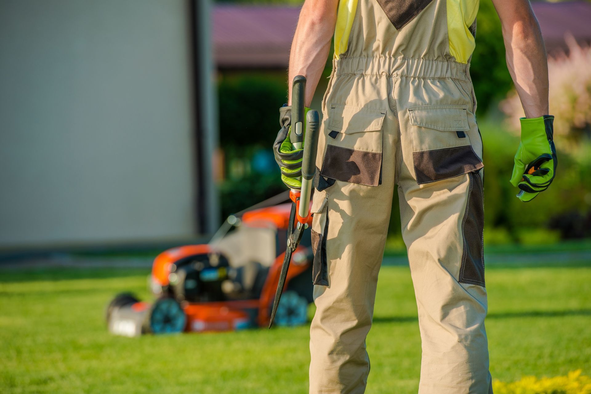 man standing holding grass cutter
