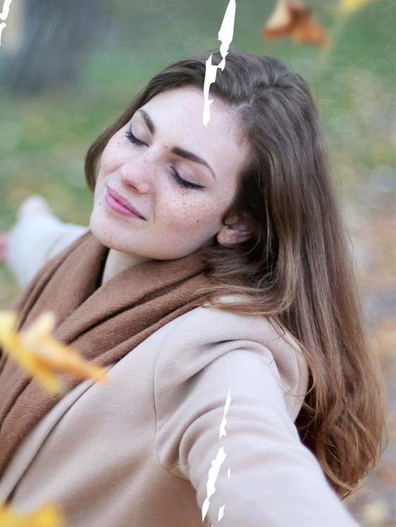 a woman with a scarf around her neck is smiling with her eyes closed