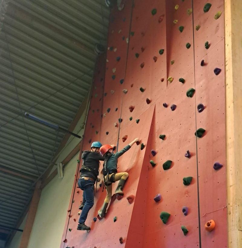 Twee mensen klimmen een rode klimmuur op
Chris Gieling Coaching en Training