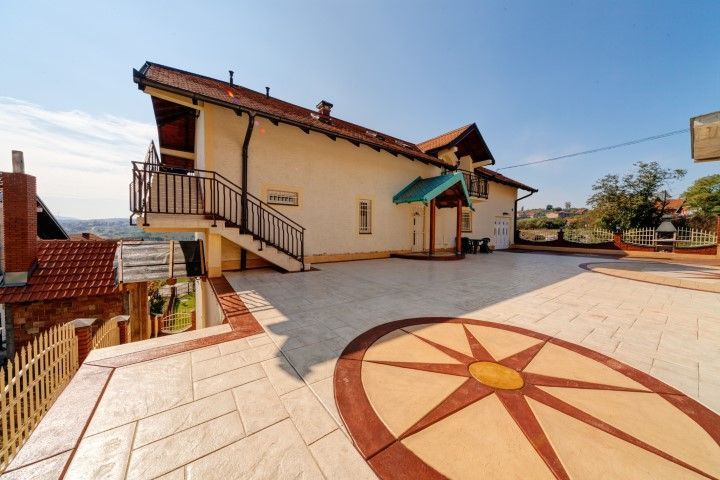 Outdoor courtyard with a tiled compass design and beige building under a clear blue sky