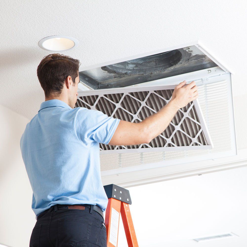 Man Removing Air Duct Filter — Douglasville, GA — Parks Davis Air Conditioning & Heating