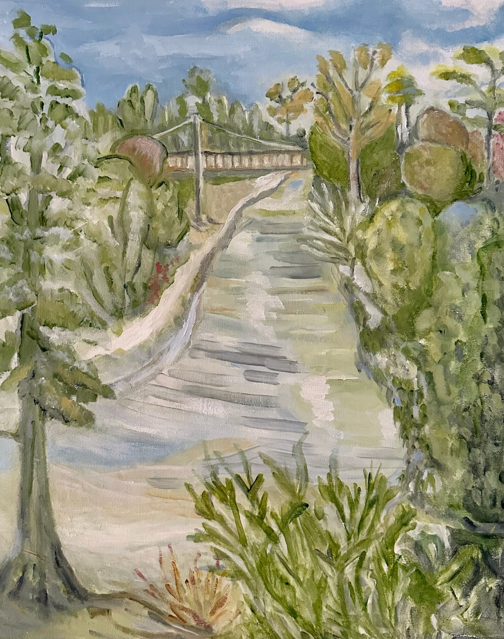 Winding canal path bordered by green trees and shrubs under a partly cloudy sky, with houses in the distance