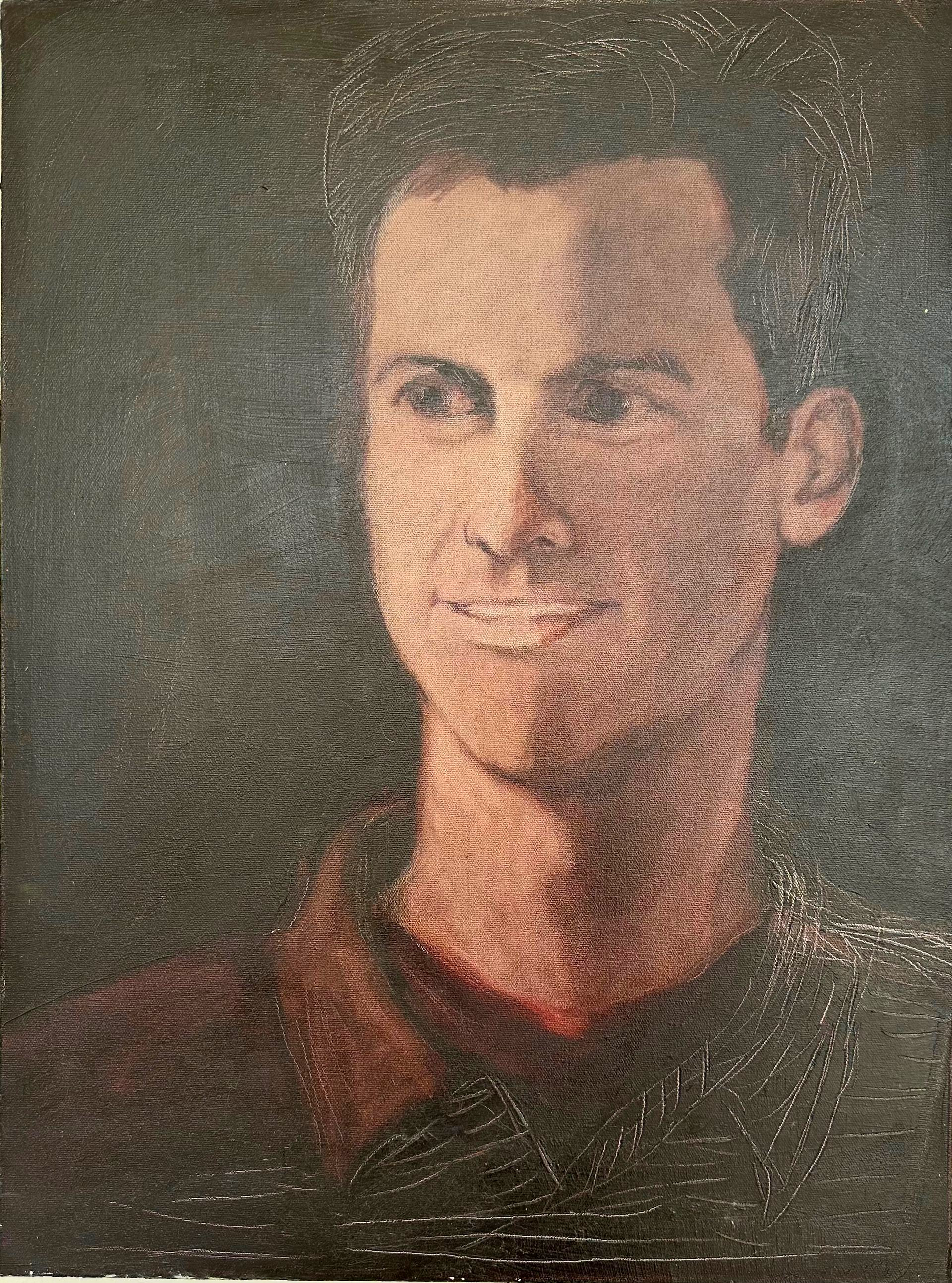 Portrait of a person in a dark shirt, facing forward against a plain dark background.