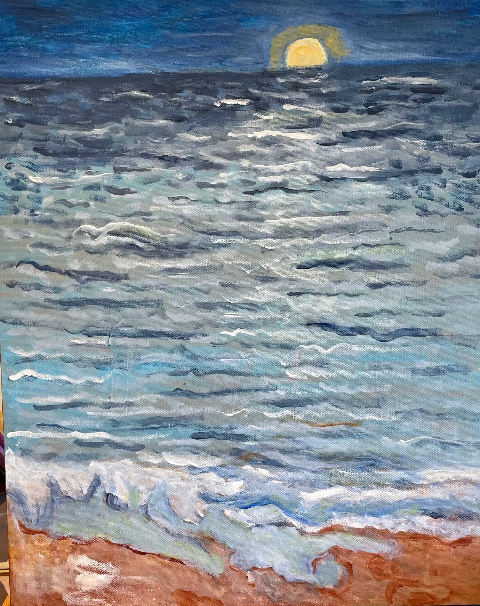 Moonlit ocean waves under a dark blue sky, with a glowing moon near the horizon and sandy shore in front