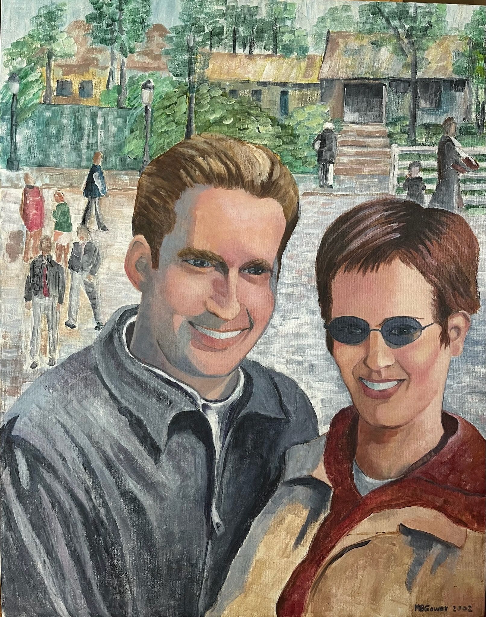 Two smiling people in sunglasses stand outdoors with a park and fountain behind them.
