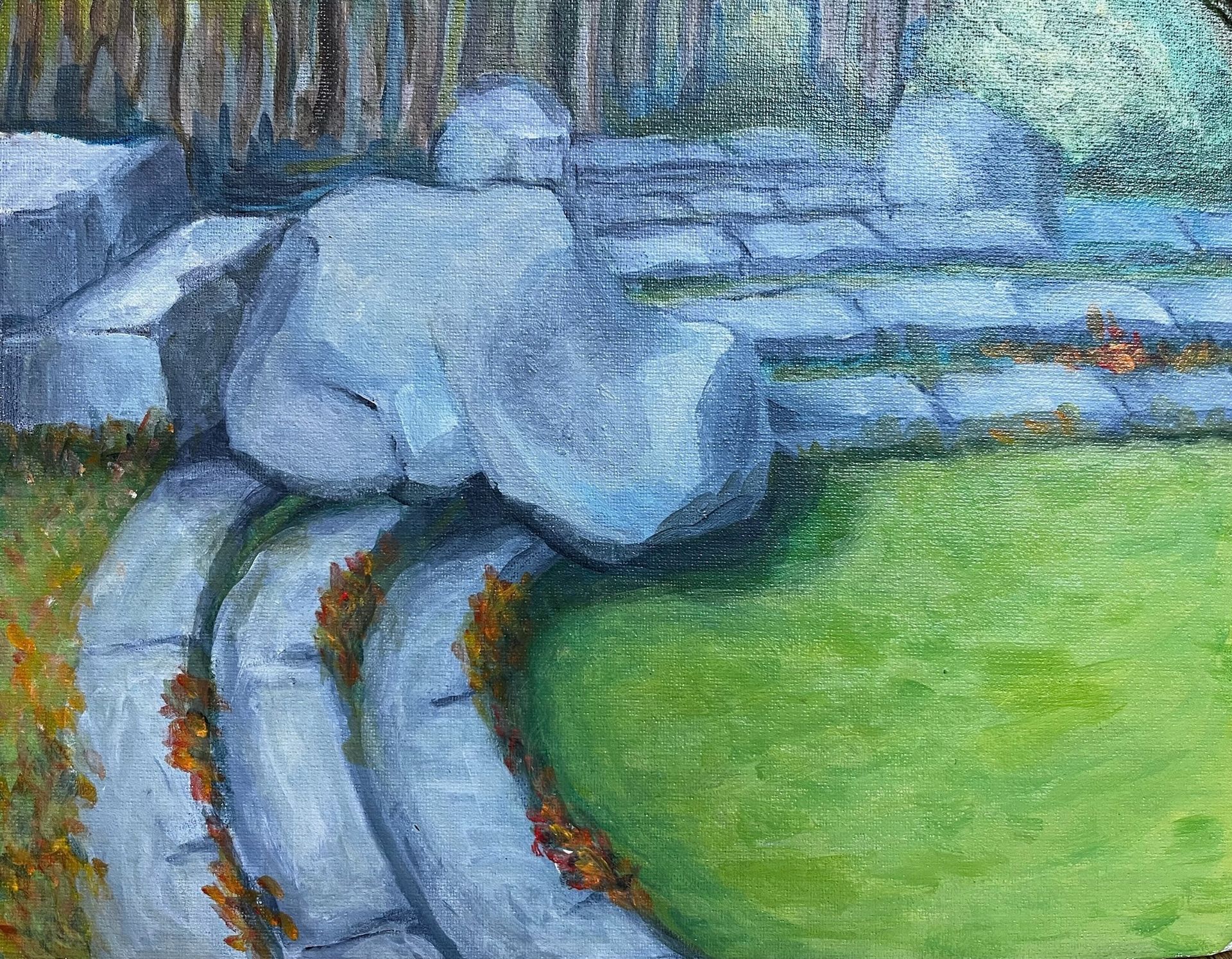 Blue-gray rocks beside curving stone steps and a bright green grassy area