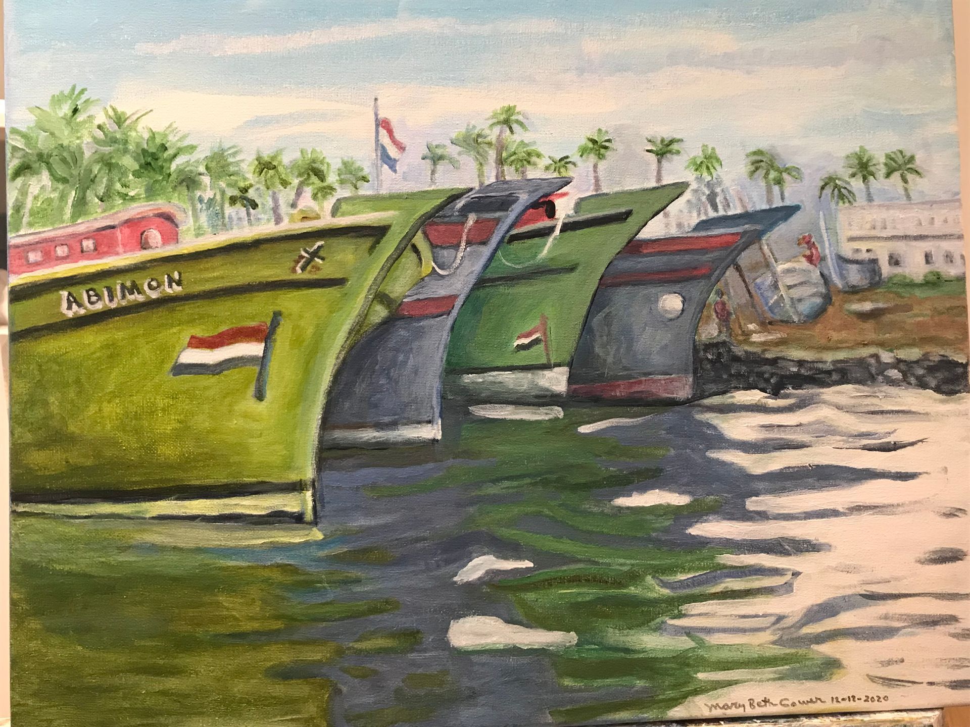 Colorful fishing boats docked by a calm shoreline with palm trees and a soft sunset sky