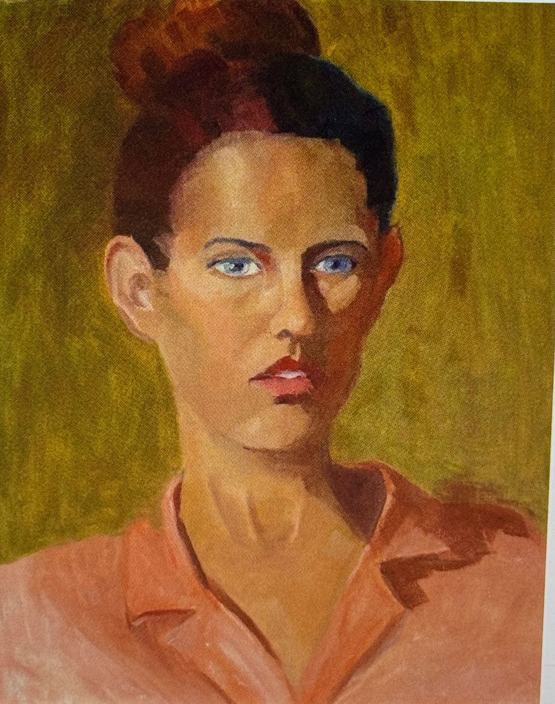 Portrait of a person in a peach shirt against a yellow background, with a serious expression.