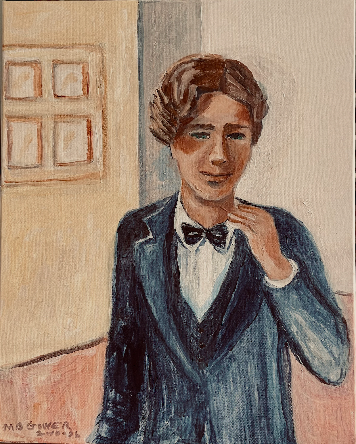 Young person in a dark suit and bow tie, standing indoors with a hand raised near the face.