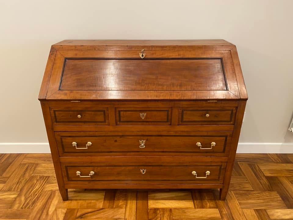 Vetrina in legno e vetro su un pavimento piastrellato, con un vano inferiore e lo sportello aperto.