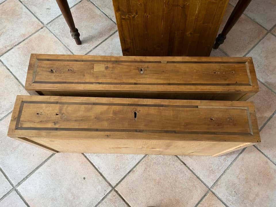 Due lunghe fioriere di legno su un pavimento piastrellato, viste dall’alto.