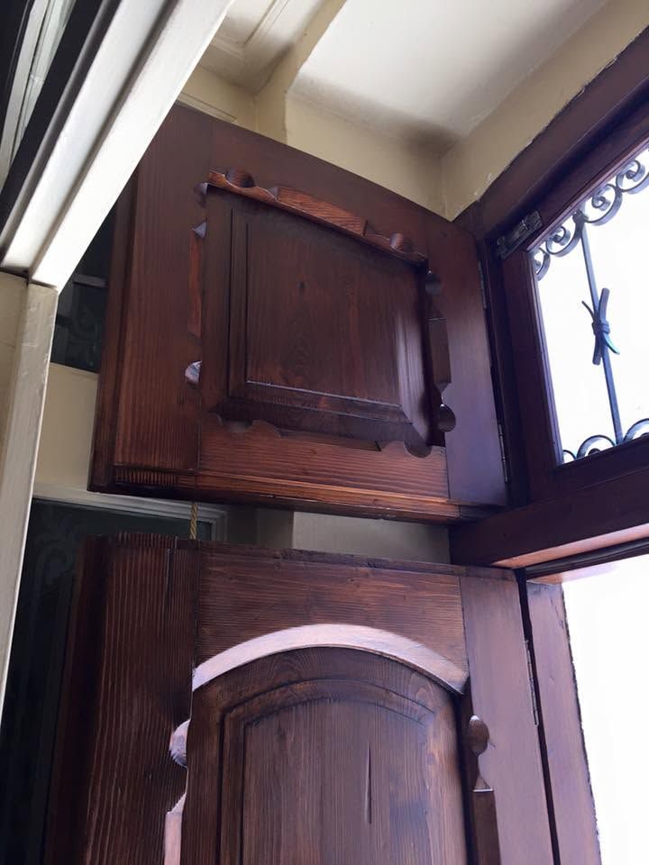 Ante in legno vicino a una finestra con inferriate decorative e cornice marrone
