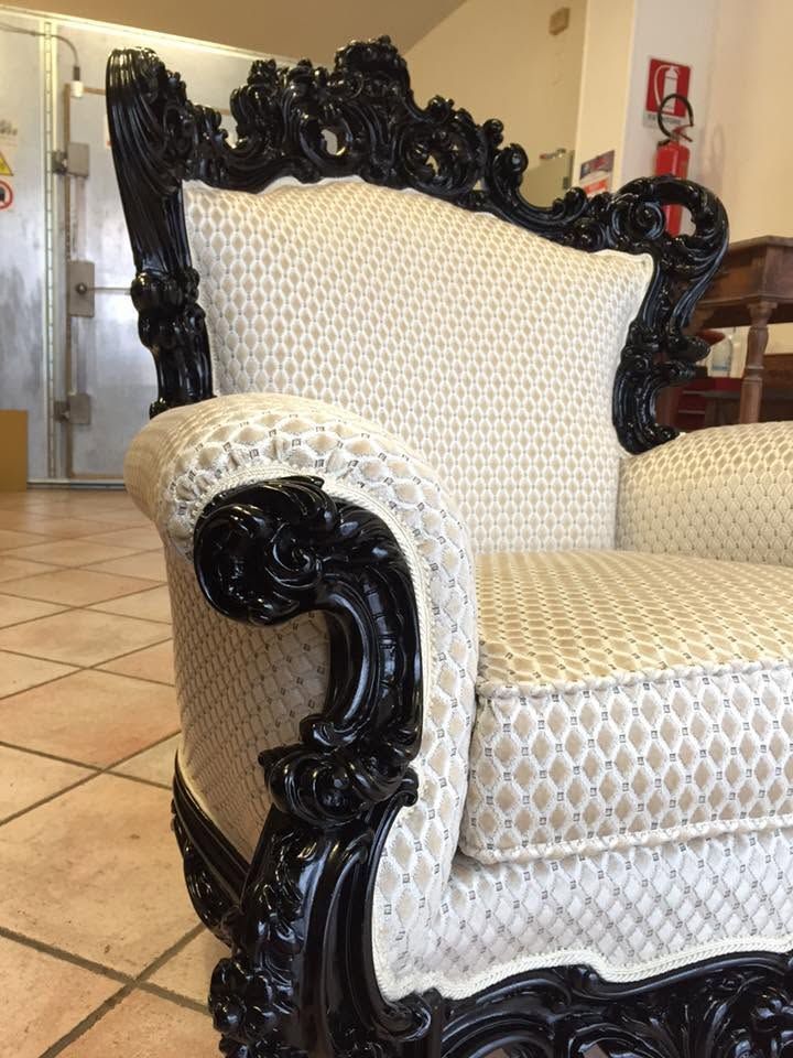Elegante poltrona imbottita nera e color crema in una stanza interna piastrellata