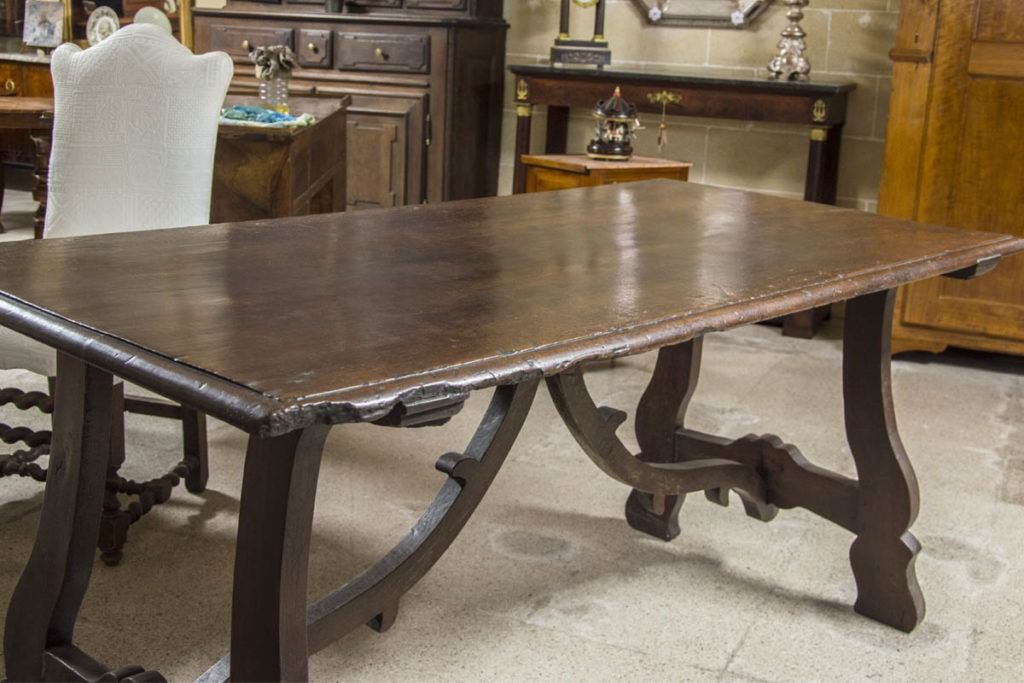 Tavolo da pranzo in legno scuro con gambe intagliate, in un negozio di mobili
