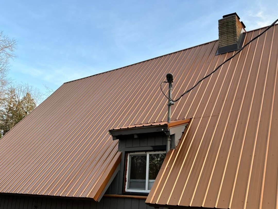 A brown metal roof with a chimney on top of it