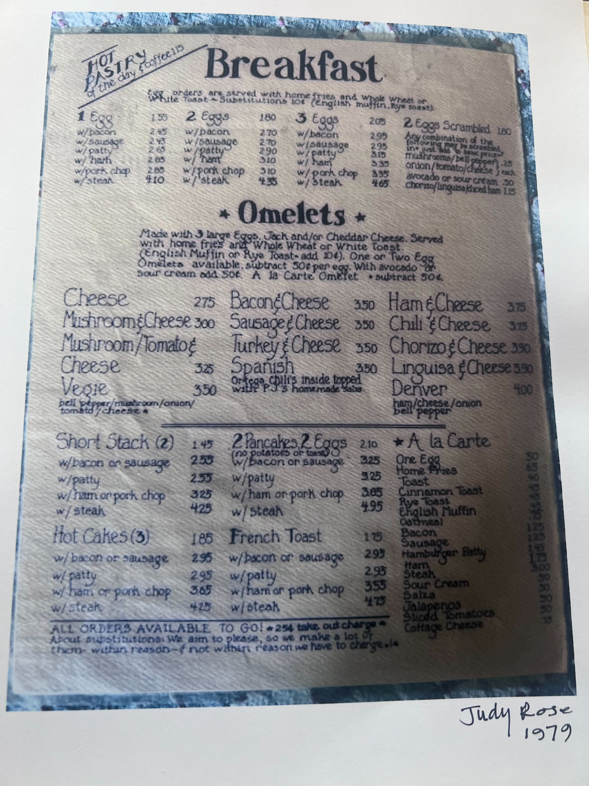 A faded restaurant breakfast menu with omelets, eggs, and other breakfast items listed in columns.