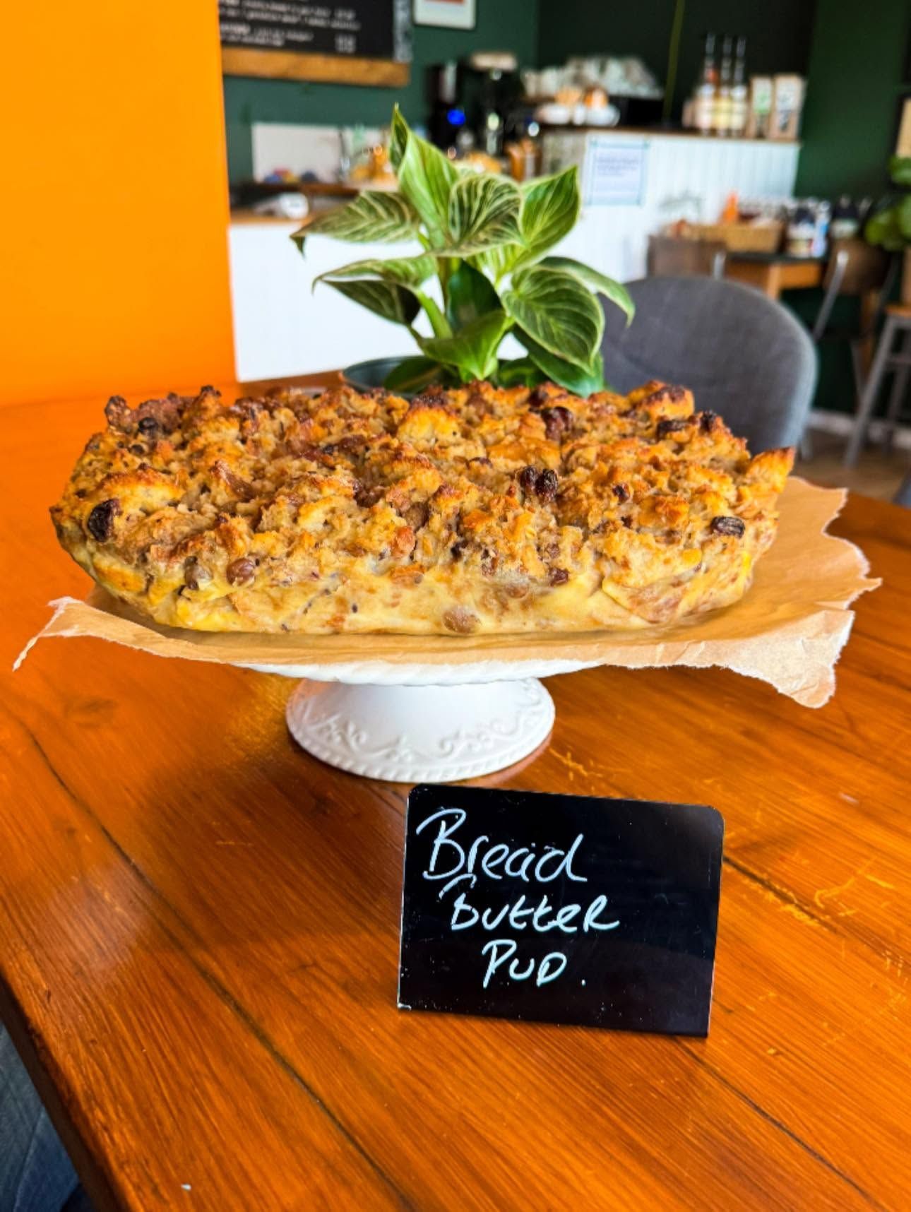 Bread steak pie on a stand with a small chalk sign, displayed in a café.