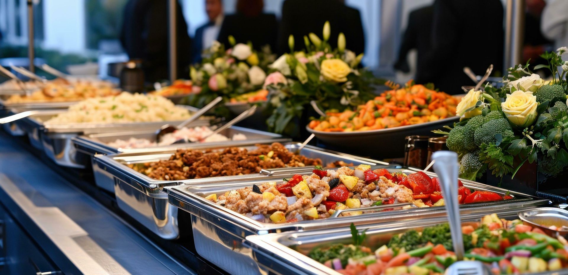 Buffet table with assorted salads, appetizers, and flowers in a banquet setting