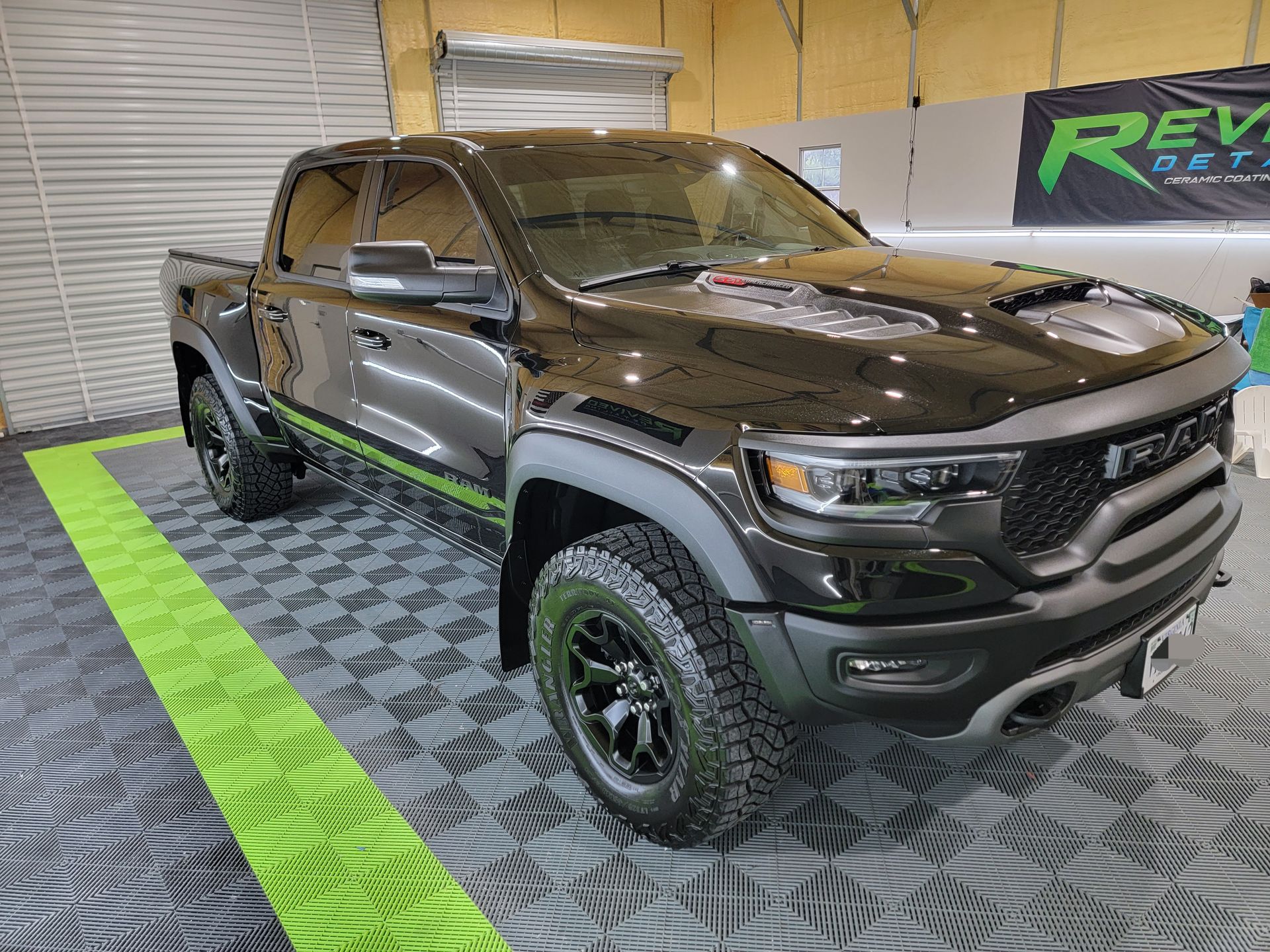 A black dodge ram truck is parked in a garage.