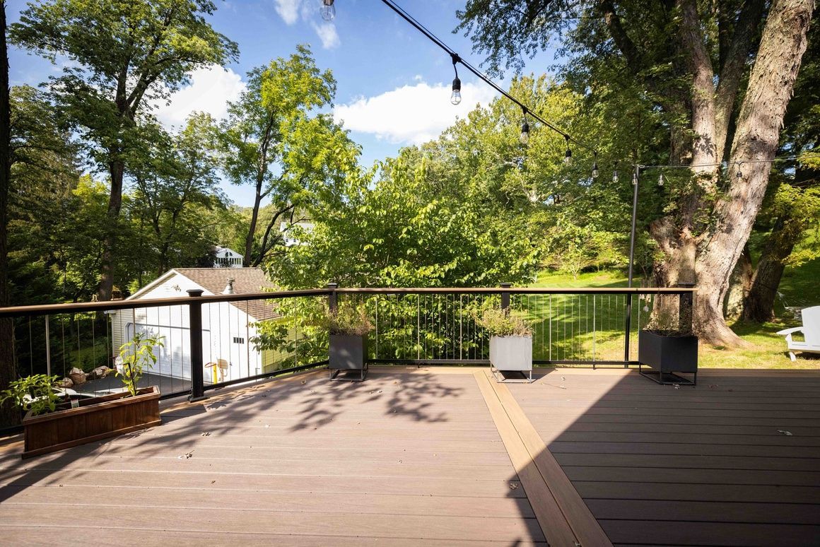 The best composite deck in Bellefonte with a fence and trees in the background.