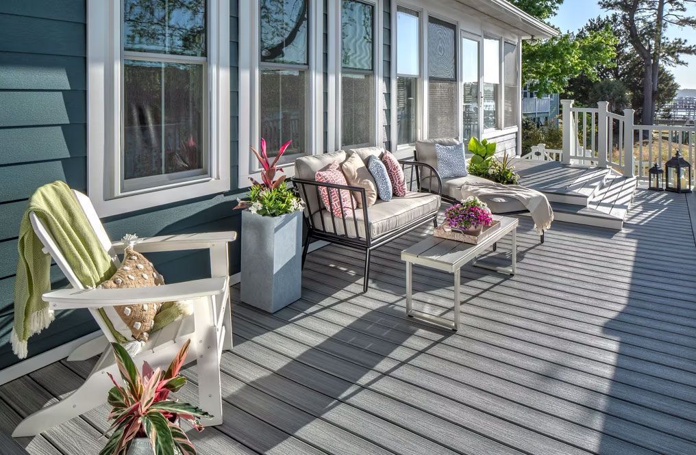 A large deck with a couch , chairs , and a table in State College. 