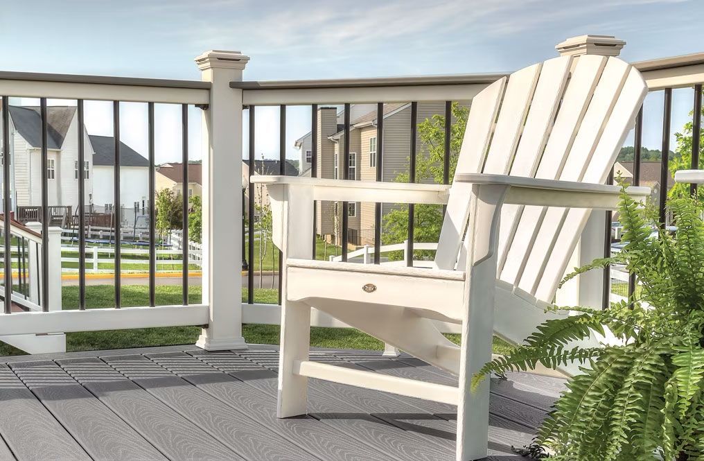 A white chair is sitting on a deck next to a fence in State College 