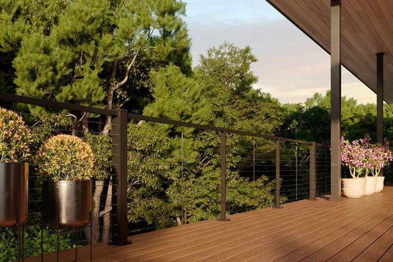 A composite TREX wooden deck with potted plants and trees in the background in state college