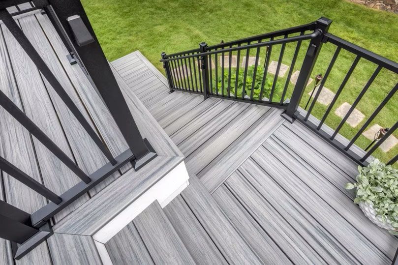 An aerial view of a deck with stairs and a black trex railing.