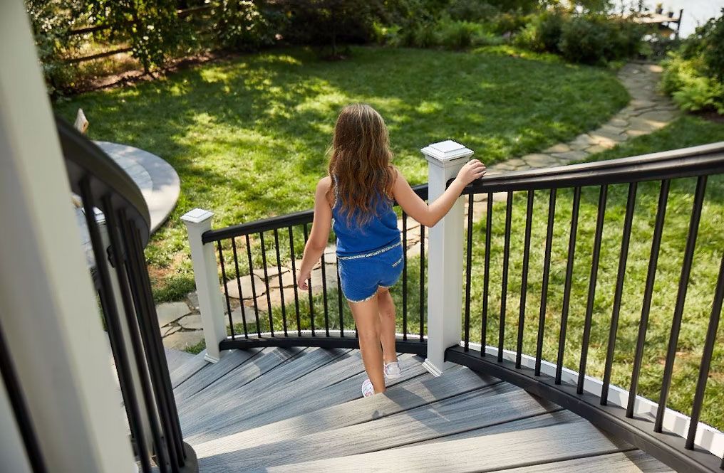 A little girl is walking up a set of stairs.