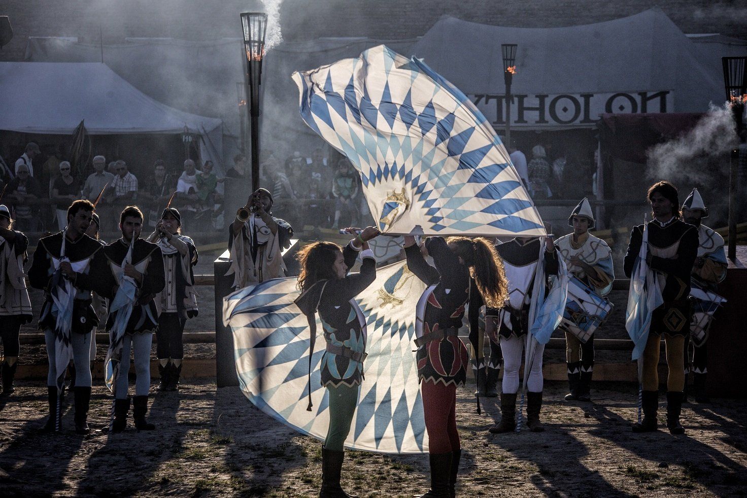 En gruppe mennesker står foran et telt og holder flag.