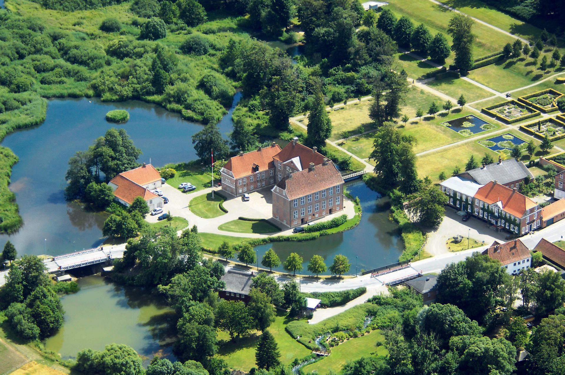 En luftfoto af et slot omgivet af vand og træer