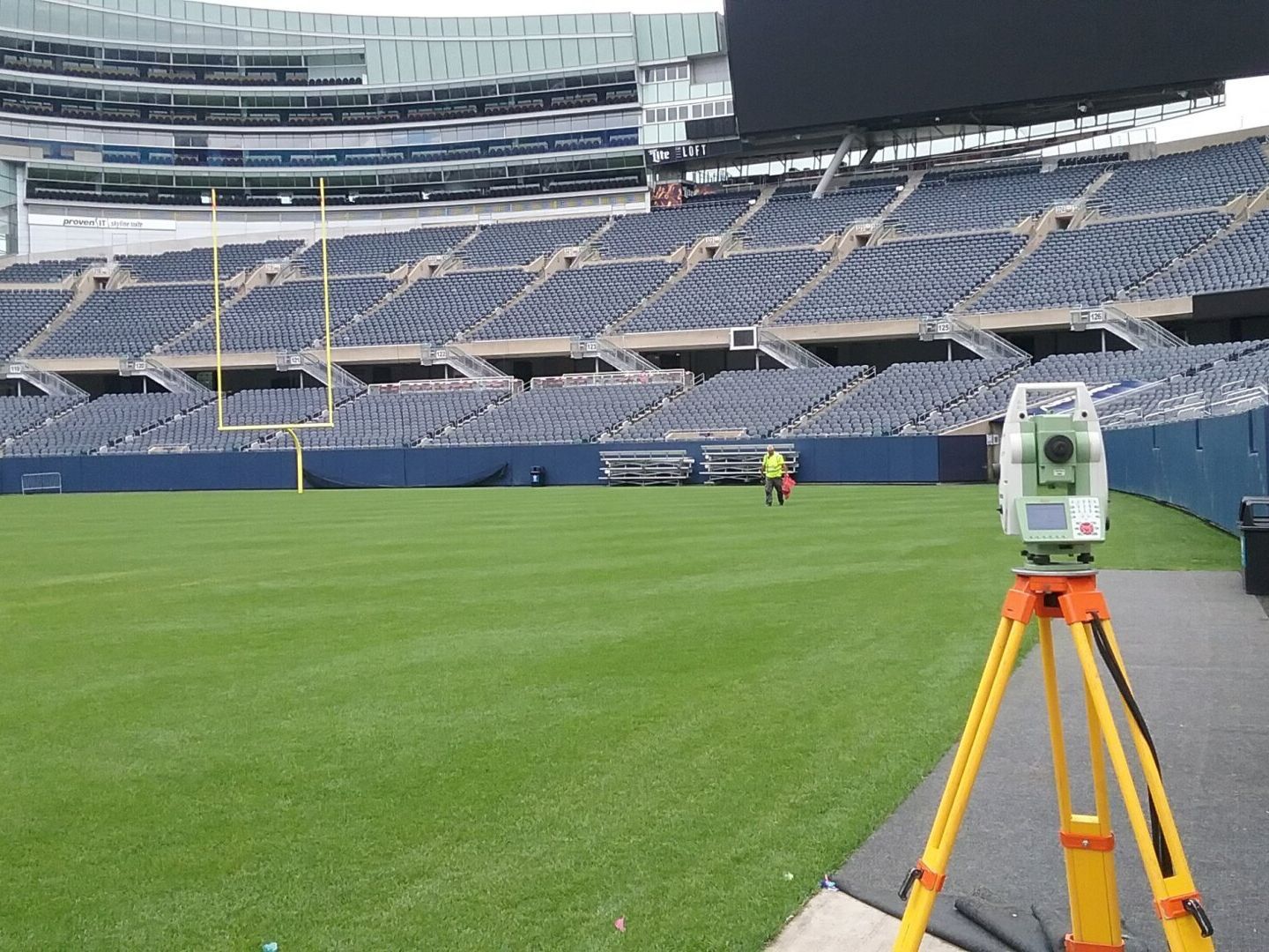 A camera on a tripod in front of an empty stadium