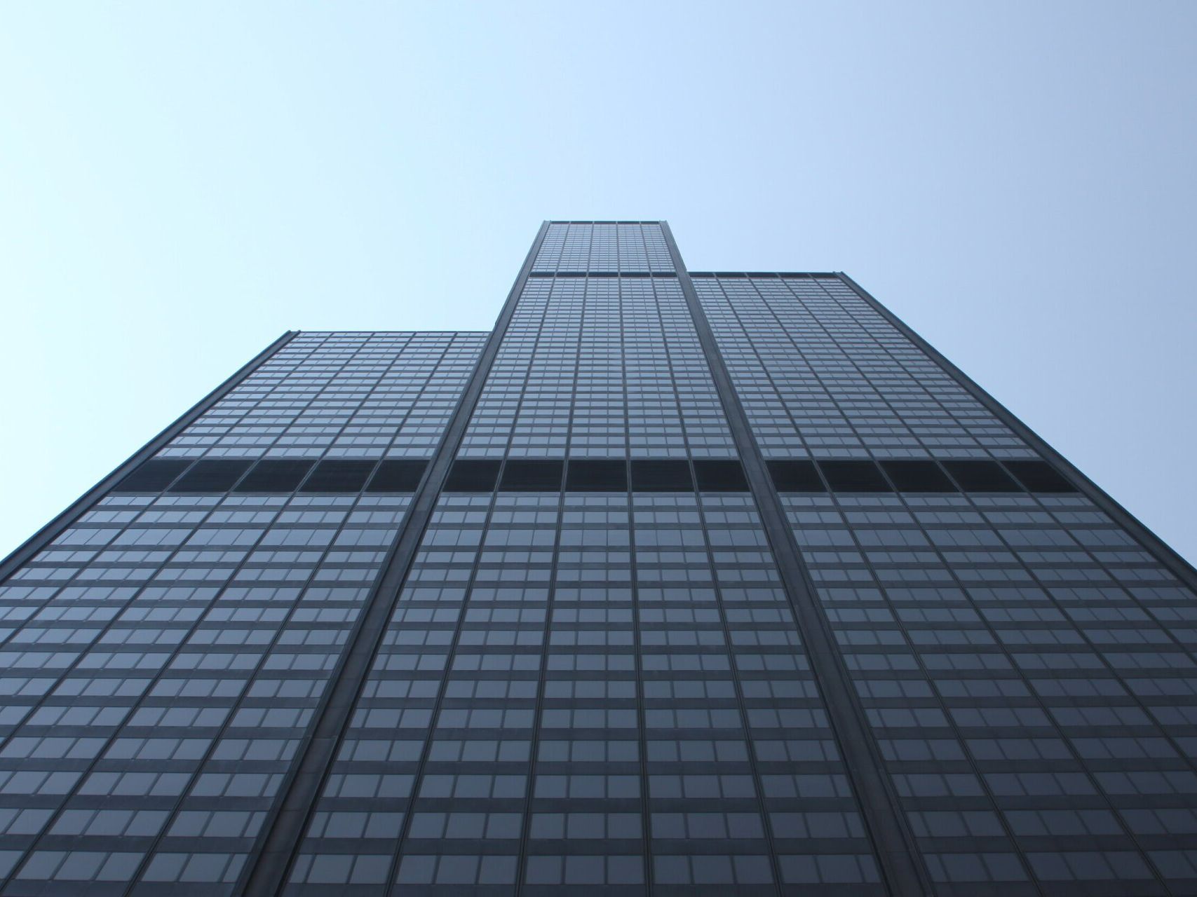 Looking up at a tall building with a blue sky in the background