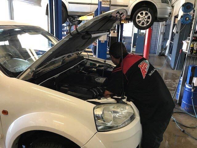 Mechanic Working Under a Raised Hood in an Auto Repair Shop — Supa Auto Services In Bundaberg, North