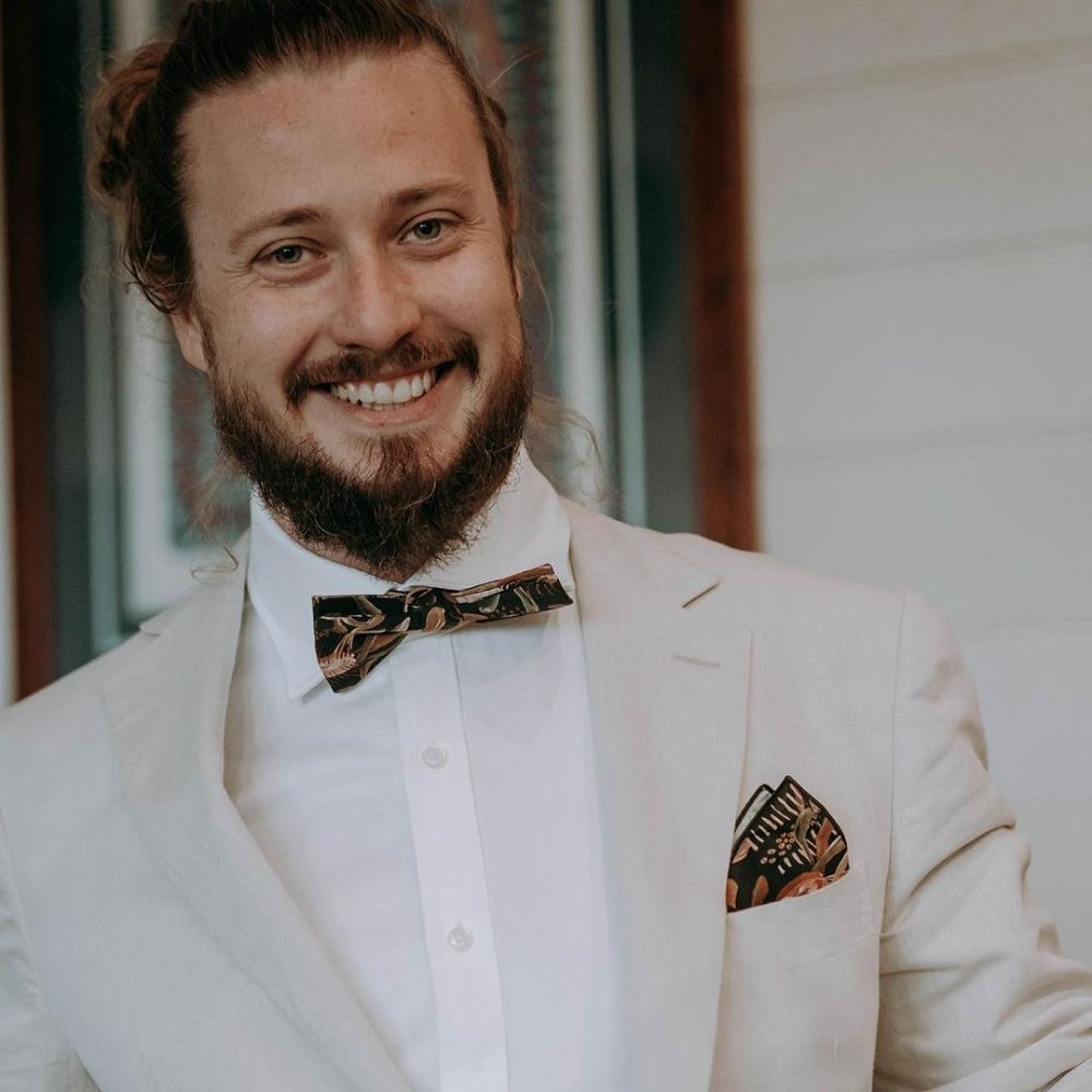 A Man with A Beard Is Wearing a White Suit and A Bow Tie — Seed + Salt Photography In Foster, NSW
