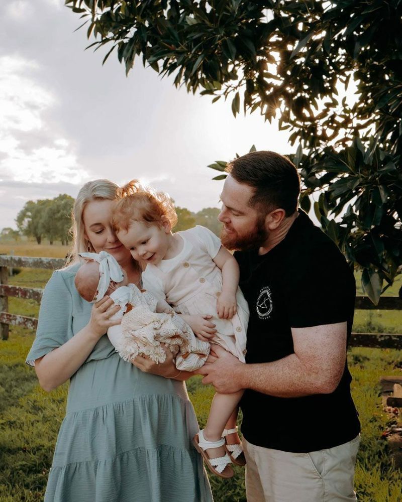 A Man and Woman Are Holding Two Children in A Field — Seed + Salt Photography In Foster, NSW