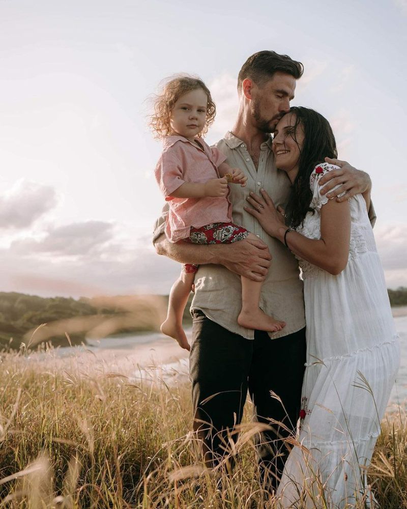 A Man and Woman Are Holding a Little Girl in A Field — Seed + Salt Photography In Coffs Harbour, NSW