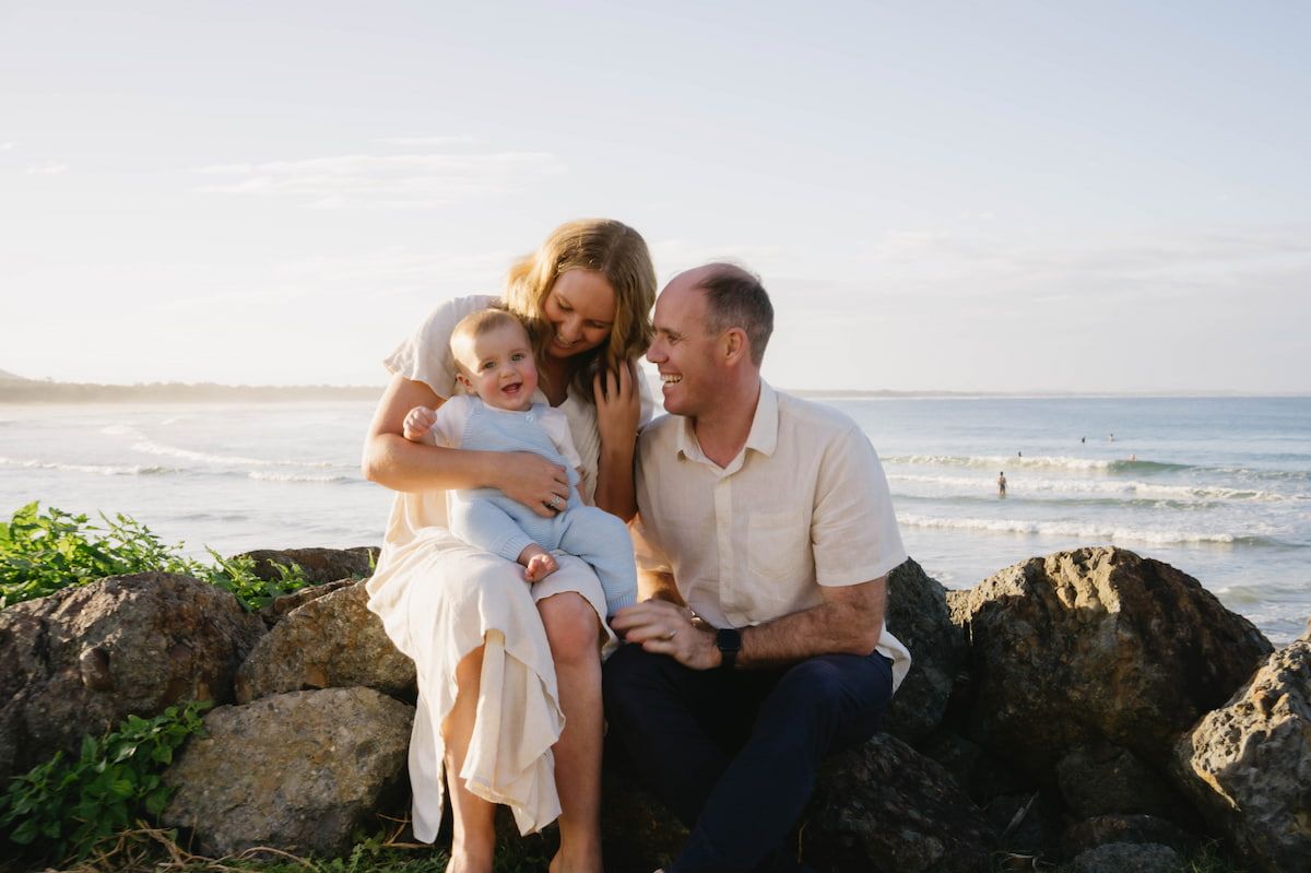 Family Sitting on Seaside Rocks, Smiling With Ocean Waves โ Seed + Salt Photography In Smithtown, NSW