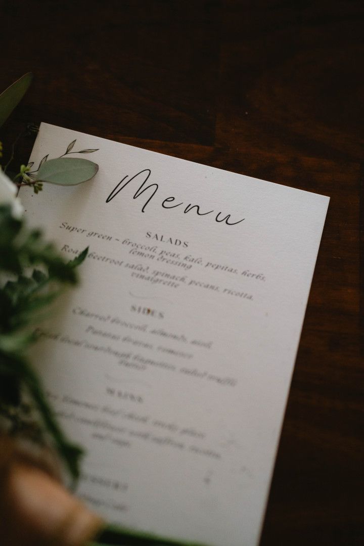 Elegant Menu Card on a Dark Table With Green Foliage Accents โ Seed + Salt Photography In Smithtown, NSW