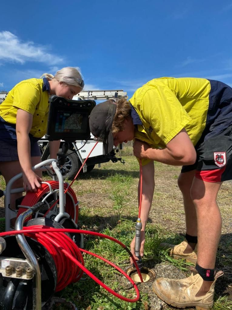 A Man and A Woman Are Working on A Machine in A Field — Gillespie Plumbing in Grafton, NSW