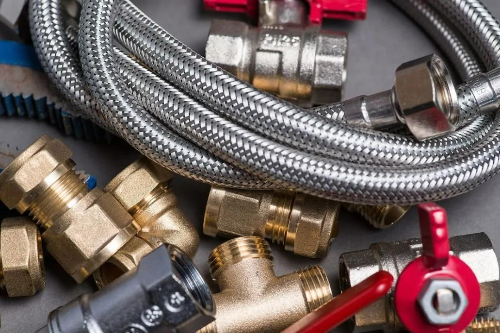 A Close up Of a Hose, Valves, and Fittings on A Table — Gillespie Plumbing in Grafton, NSW