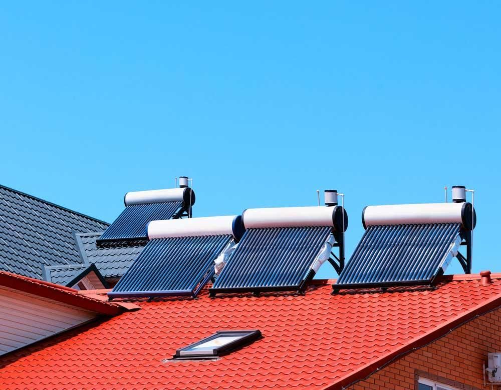 There Are Three Solar Panels on The Roof of A House — Gillespie Plumbing in Grafton, NSW