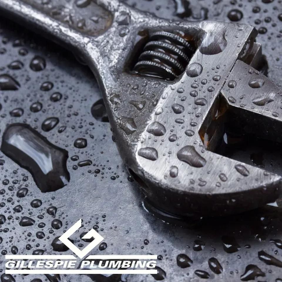 A Wrench Is Sitting on A Wet Surface with Gillespie Plumbing Written on The Bottom — Gillespie Plumbing in Grafton, NSW