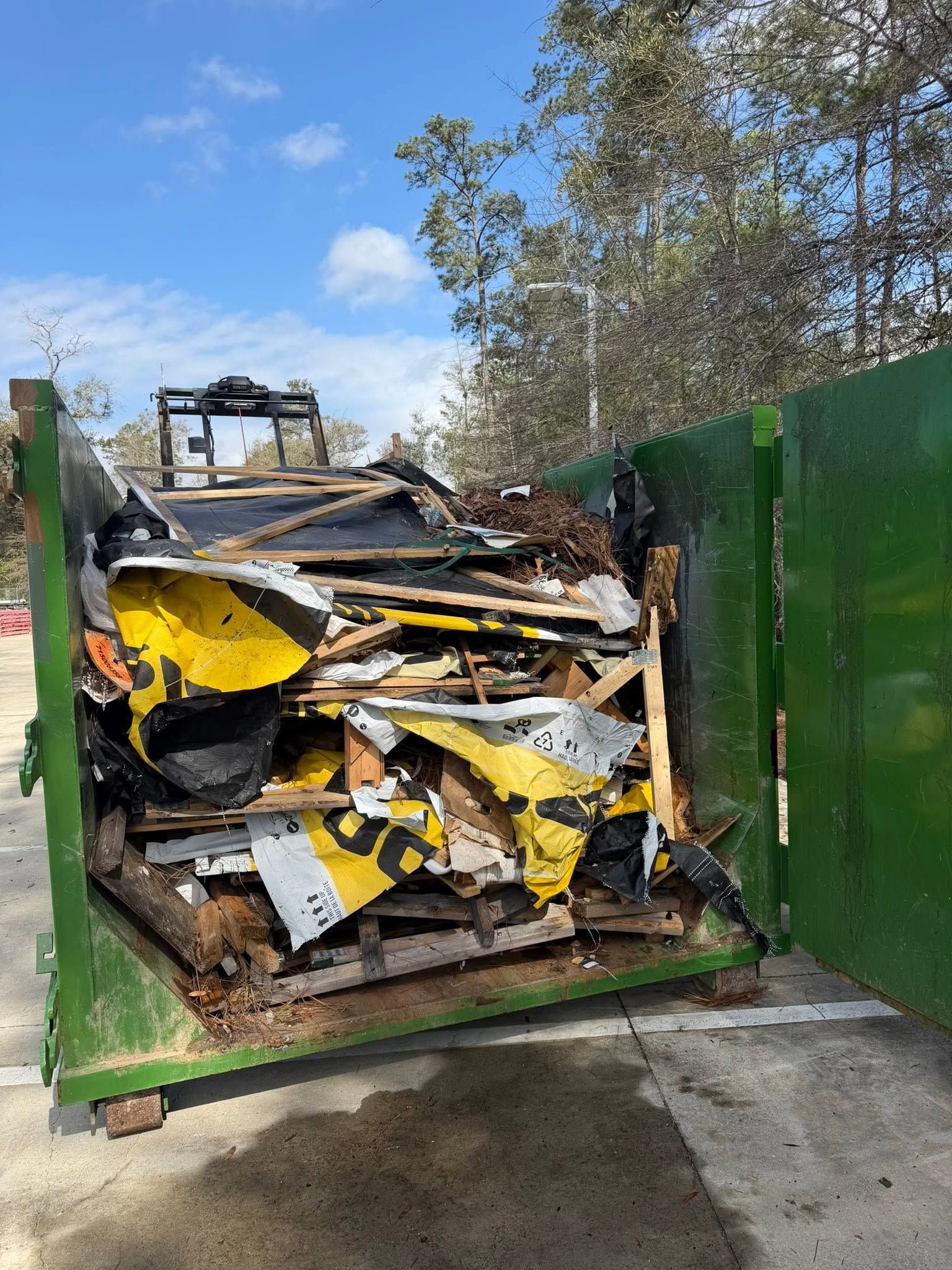 Yellow loader dumping dirt into black dump truck beside white pickup at a construction site