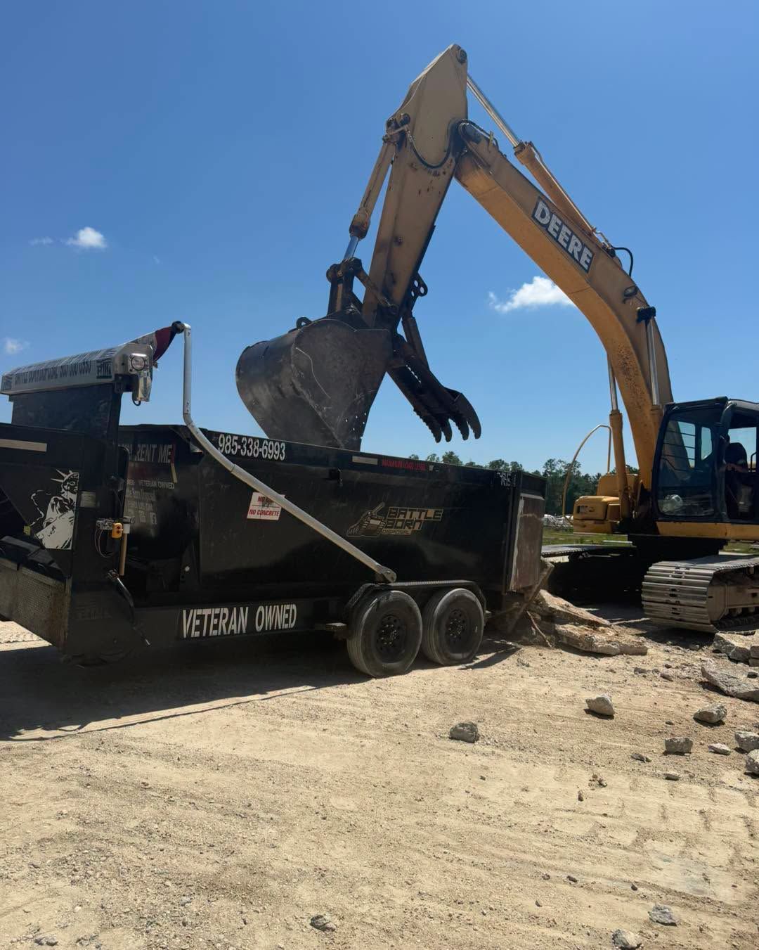 Yellow excavator amid rubble at a demolition site