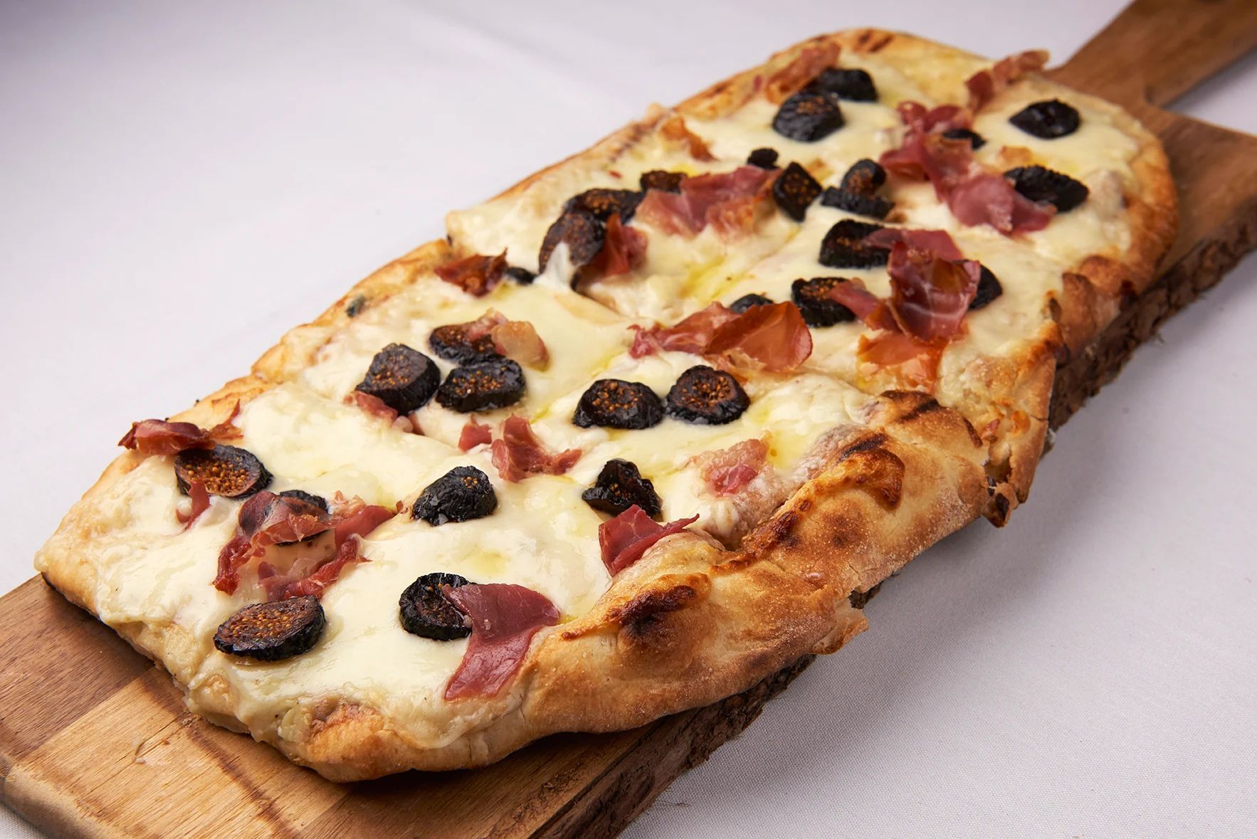 A pizza is sitting on a wooden cutting board.