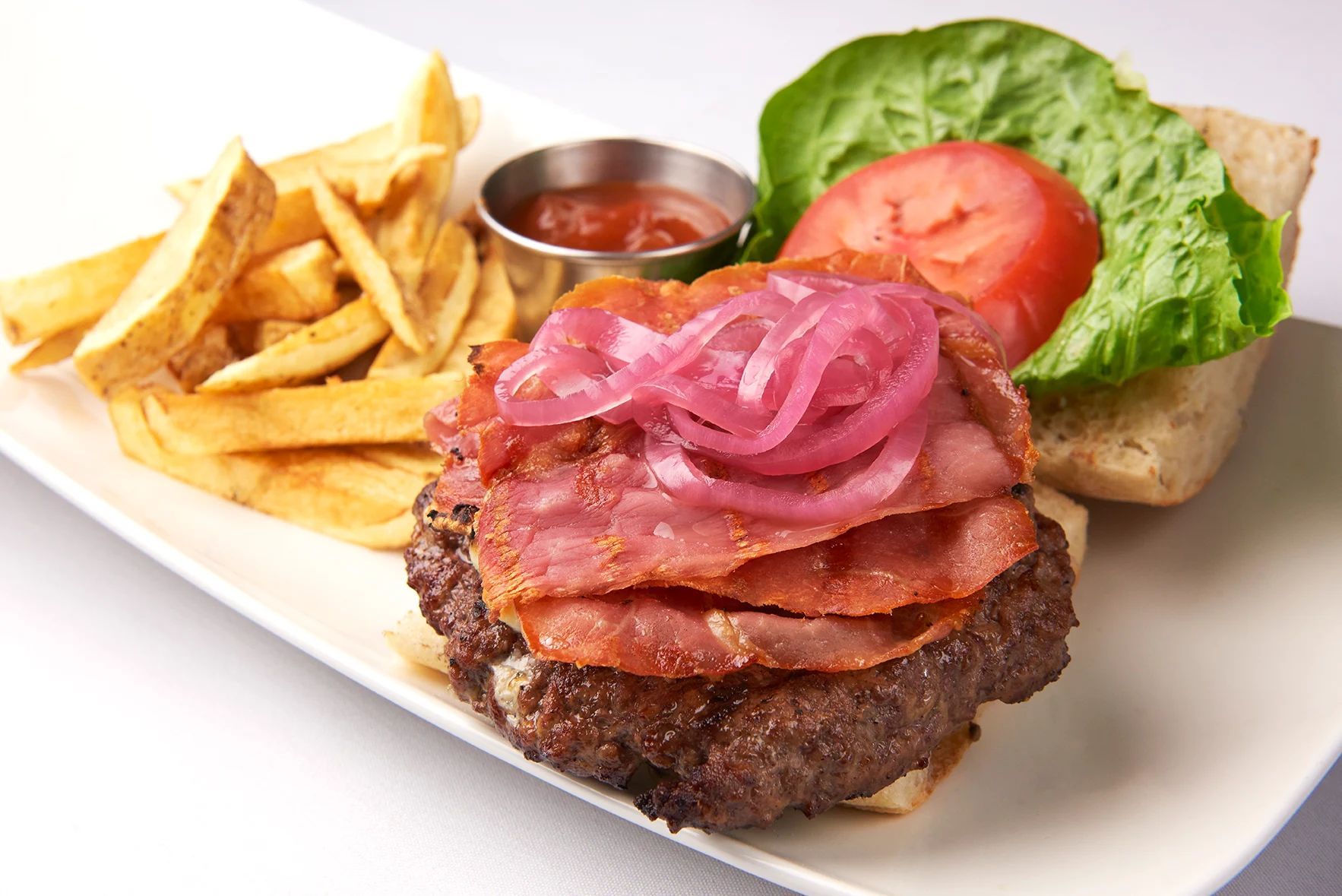 Limoncello Burger A white plate topped with a hamburger and french fries