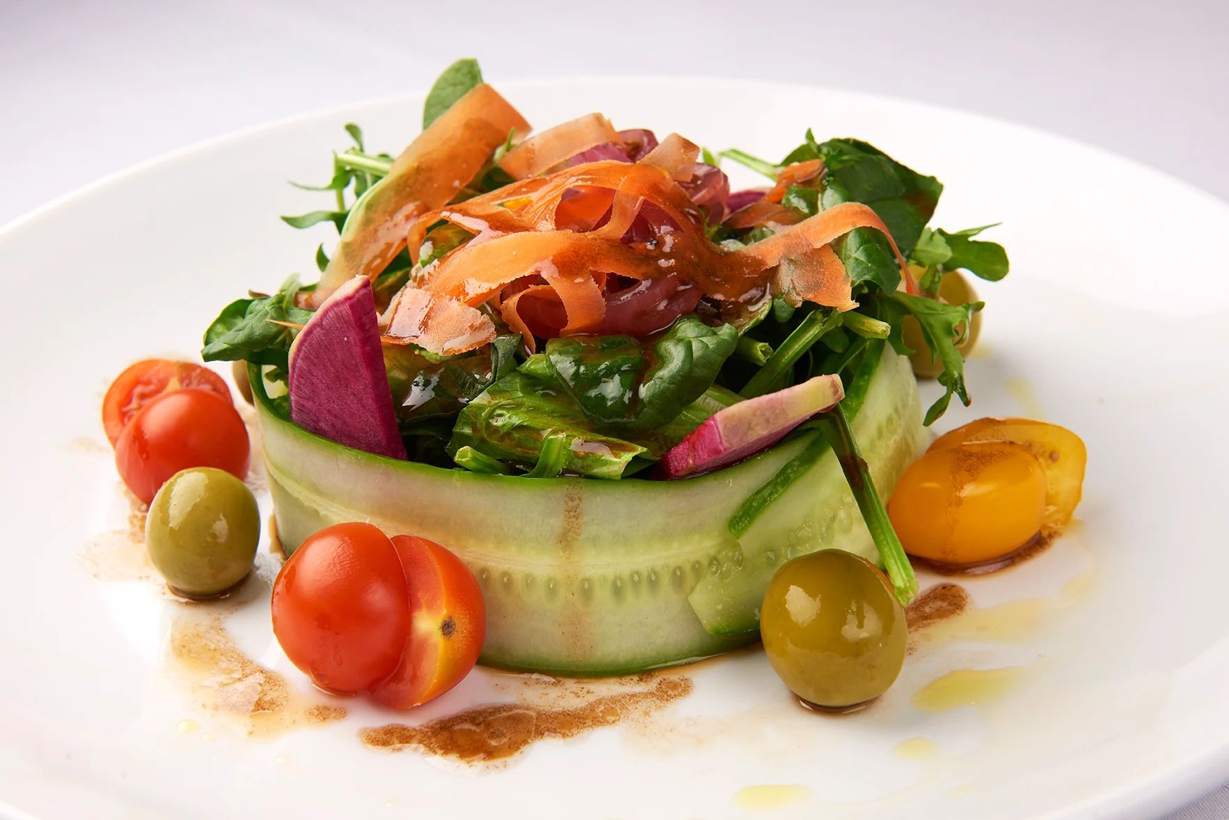 Spring Salad A salad with tomatoes and olives on a white plate