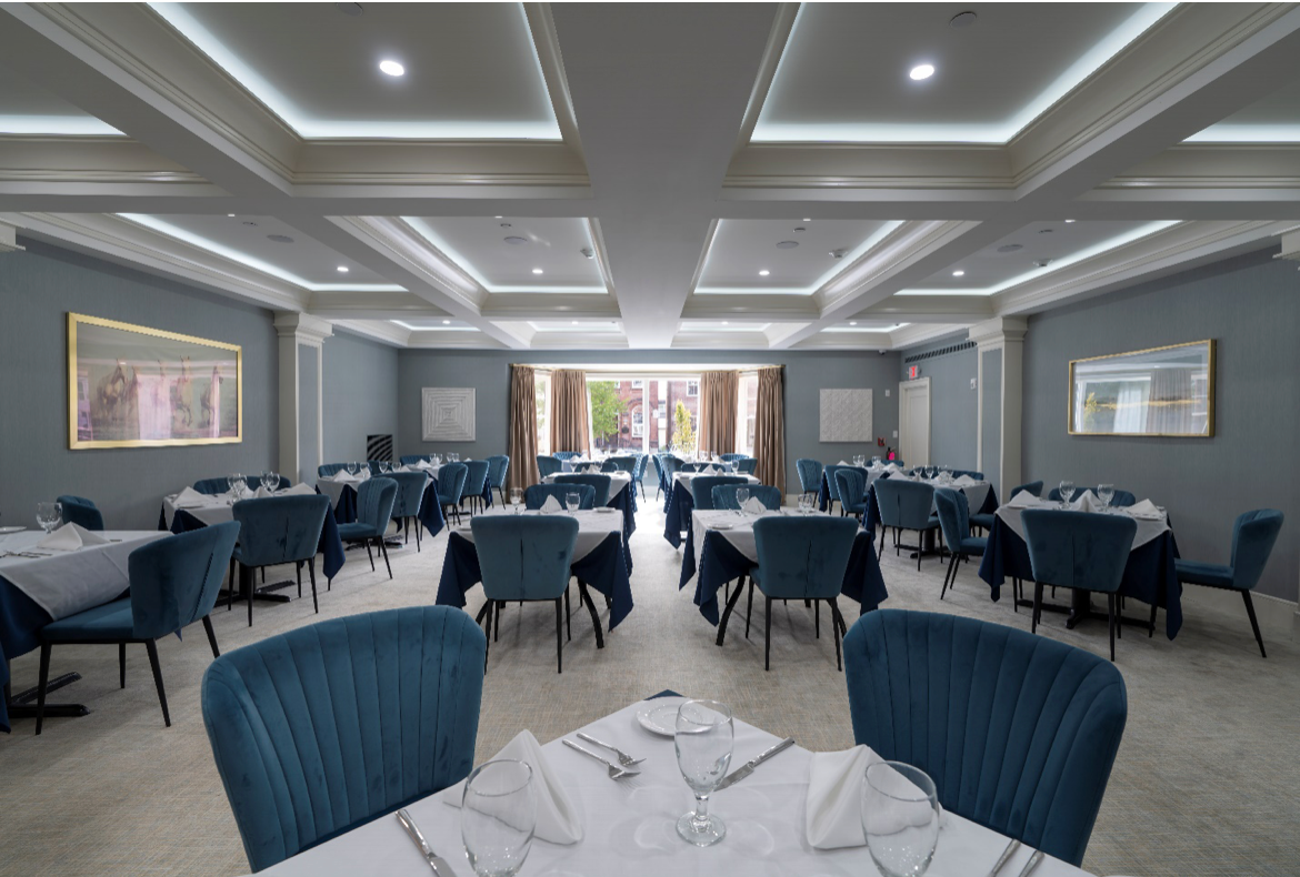 A large dining room with tables and chairs set up for a banquet.