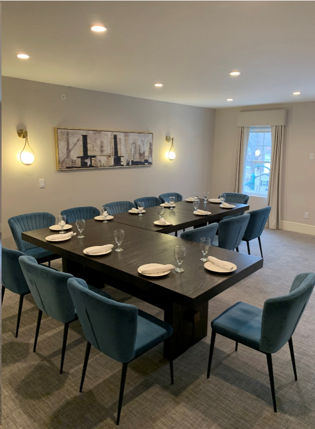 A conference room with a long table and blue chairs
